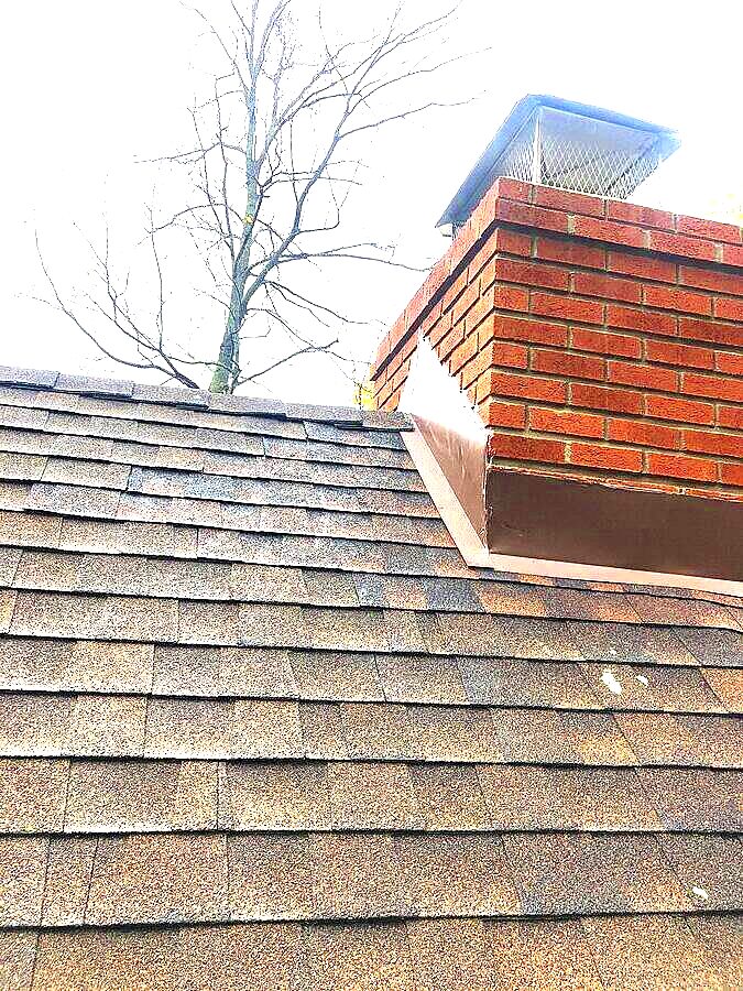 Chimney flashing where brick masonry meets roof shingles