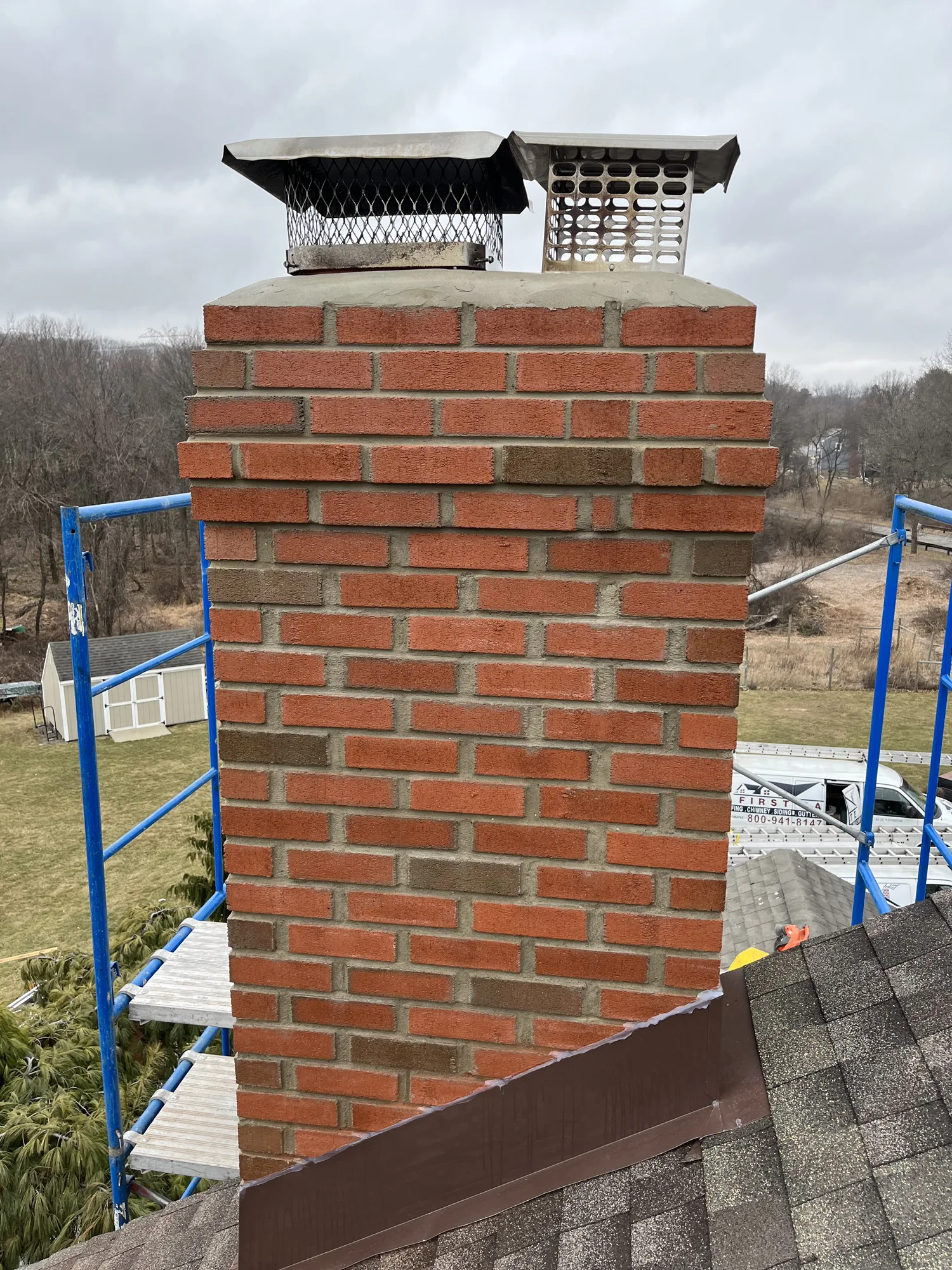 Brick chimney masonry beside access scaffolding