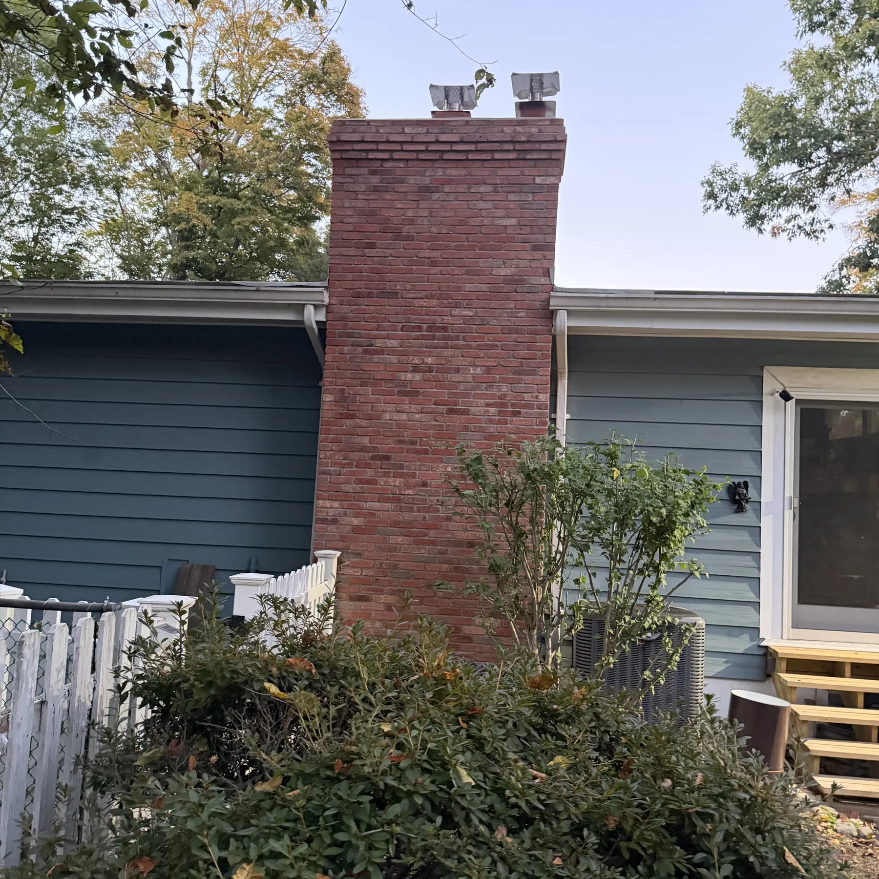 Front view of completed brick chimney masonry above the roofline