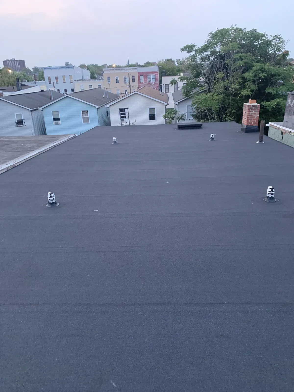 Completed dark flat roof membrane with vent penetrations